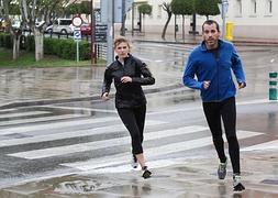 Dos jóvenes corren por las calles de Logroño en un día de lluvias. / SONIA TERCERO