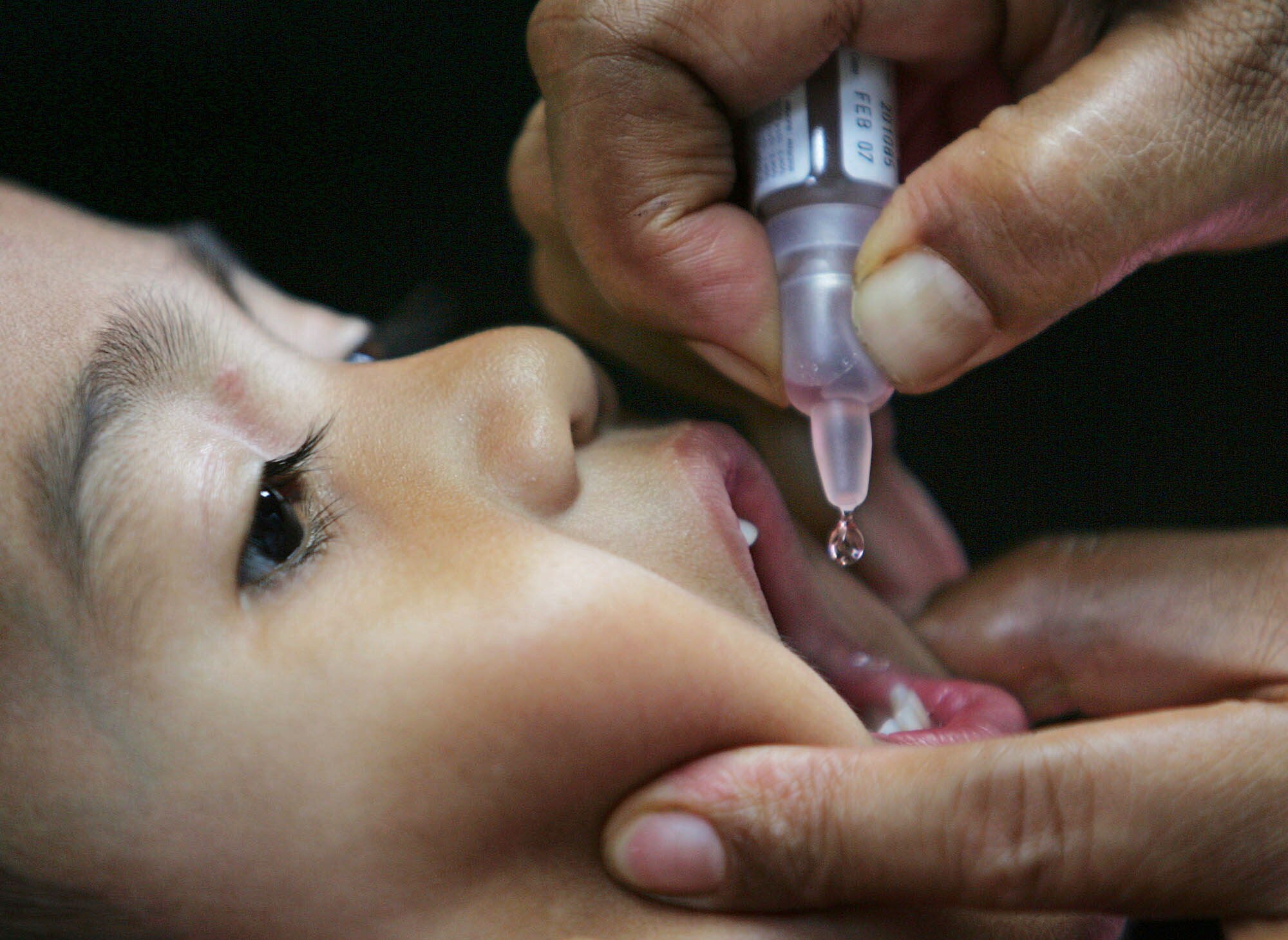Un niño recibe una vacuna bebible./
