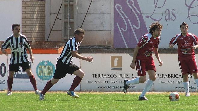 El blanquinegro Óscar persigue a un jugador alfareño con el balón ante la atenta mirada de su compañero Joseba. 