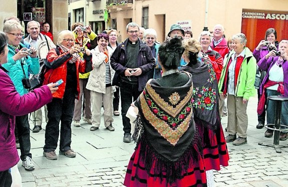 Turistas retratan a dos 'doncellas', en el reparto del 2013. 