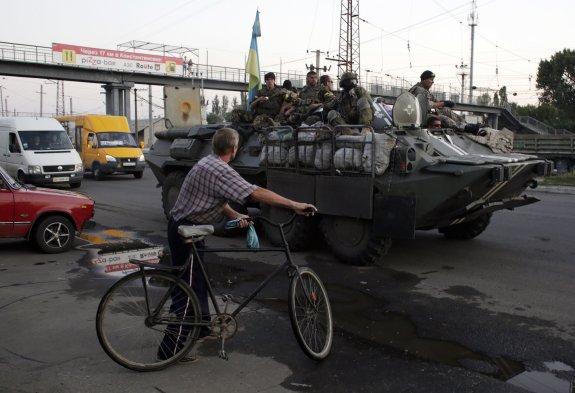 Un ciclista observa el paso de un tanque en Donestk. 