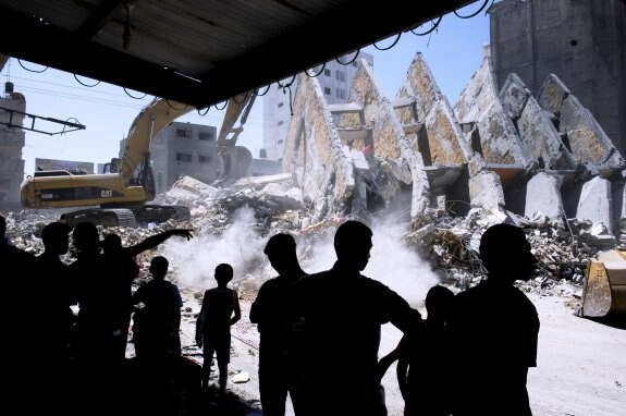 Una excavadora desescombra un edificio alcanzado por proyectiles israelies en Gaza. 