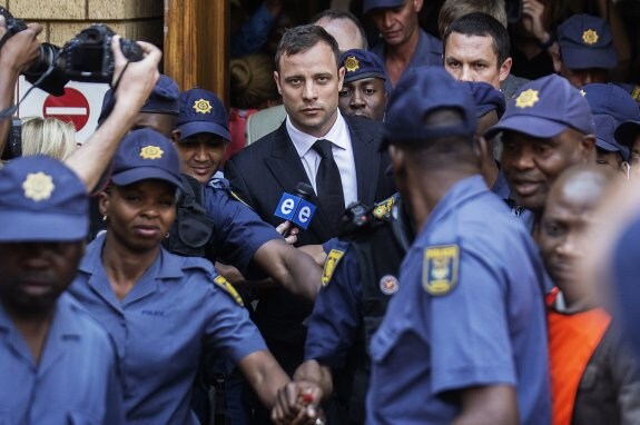 Oscar Pistorius abandona la sala del juicio rodeado de agentes. 