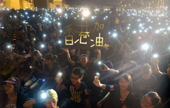 Los participantes en la protesta de Hong Kong encienden sus teléfonos móviles durante su protesta. 