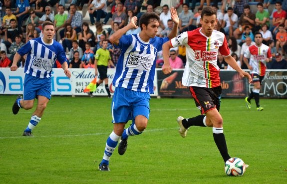 Esaúl conduce el balón sorteando la presión del blanquiazul Gabri.