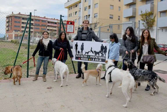 Fuera y dentro. Miembros de la Asociación de Propietarios de Perros de La Rioja antes y después de entrar en la zona acotada en Los Lirios, aunque sin acondicionar, para mascotas. 