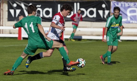 De Val avanza con el esférico ante la presión de Capellán, jugador del La Calzada. 