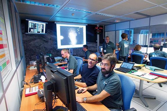 Alejandro Blázquez (en primer plano) con unos compareños siguiendo las maniobras de Philae en el Centro de Estudios Espaciales de Francia.