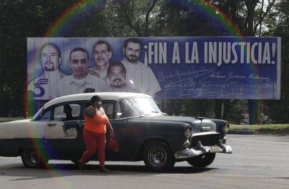Una mujer camina por una calle de La Habana presidida por un cartel que reclama la liberación de 'Los Cinco'. 
