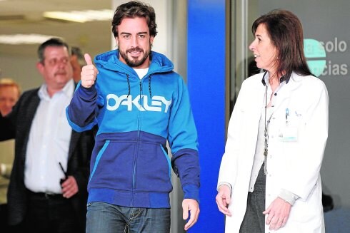 El piloto Fernando Alonso saluda a los medios en el hospital. :: efe