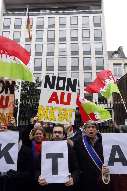 Protesta ante la Embajada alemana en París en contra de renegociar el rescate a Grecia; a la izquierda, el ministro heleno de Finanzas:: afp