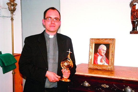 Adam Jeszka, con el relicario que guarda la sangre de Juan Pablo II y una imagen del Papa. :: sanda