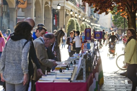 Varios logroñeses ojean los títulos expuestos en uno de los 'stands' de una librería riojana, ayer en la calle Portales. :: justo rodríguez