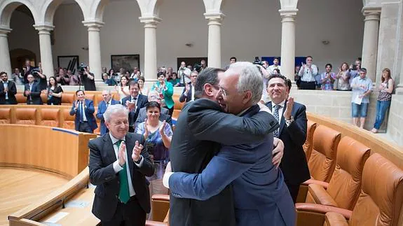 Aplausos en el Parlamento a Ceniceros, al que abraza Sanz tras su investidura.