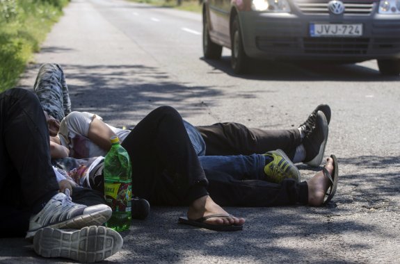 Una familia de emigrantes descansa tras llegar a Hungría por la frontera serbia. :: CSABA SEGESVARI / afp