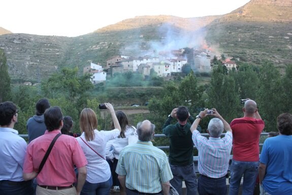 Las viviendas habitadas de Peroblasco dibujaron humo de colores en el anochecer para reclamar que se atiendan sus necesidades. :: 