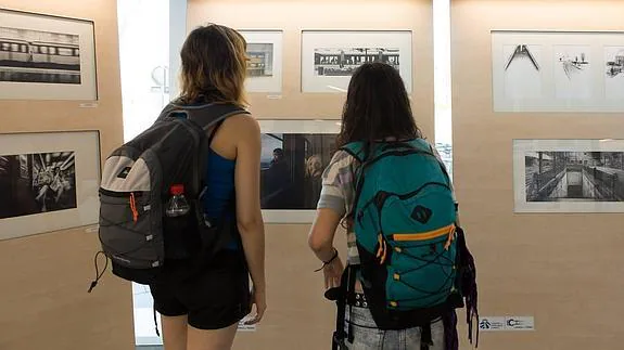 Unas jóvenes viajeras observan algunas de las fotografías.