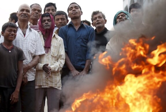 Un grupo de manifestantes permanece tras una hoguera durante el bloqueo de la autopista que conecta Nepal con India. 