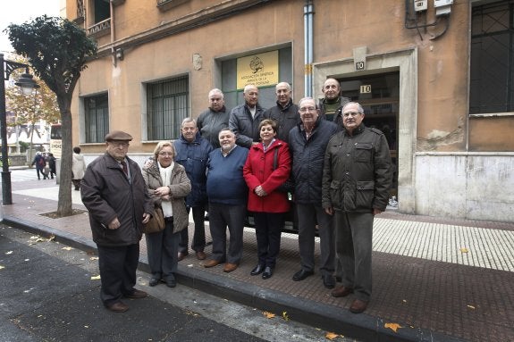Miembros de la junta directiva y voluntarios de la Asociación Benéfica de Amigos de la Hucha Popular posan ante su sede. :: Justo Rodríguez
