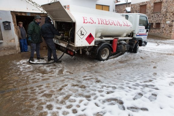 Un camión de gasoil abastece a un vecino de El Rasillo, también nevado. :: sonia tercero