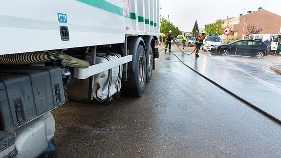 Los bomberos limpian la carretera del combustible derramado. 