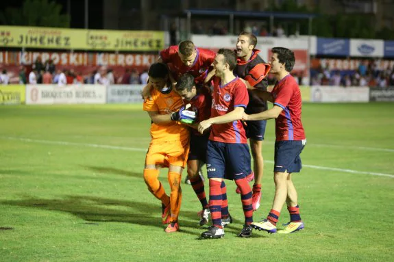 Los jugadores del Calahorra se abrazan a Txerra, su portero, tras la tanda de penaltis. :: juan marín