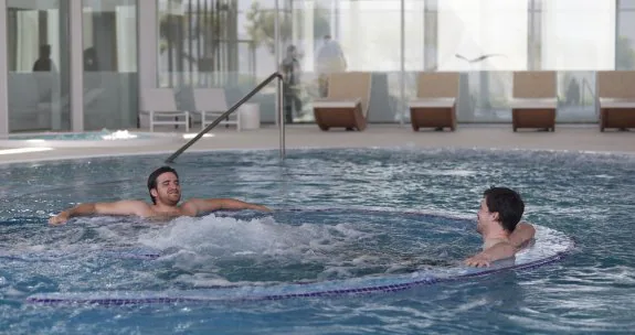 Dos hombres disfrutan de las aguas termales de un balneario. :: s. tercero