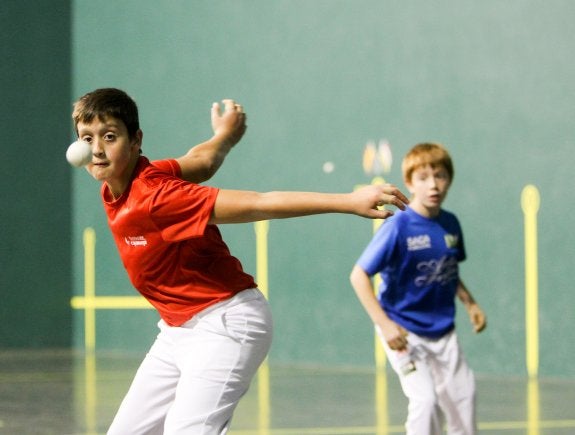 Un pelotari escolar se prepara para devolver la pelota. :: F.d.