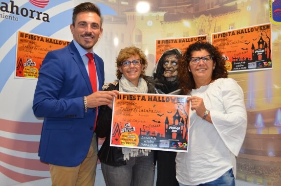 Óscar Eguizábal, Ana Pellejero y Maru Pérez con los carteles y un zombi que estará en la fiesta. :: i. á.