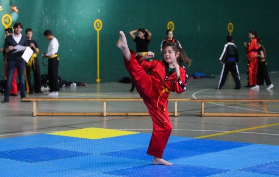 Una escolar realiza una forma durante una jornada de kickboxing. :: F.d.