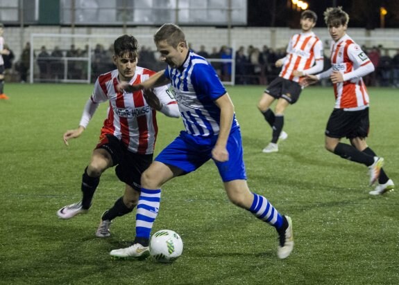 Javito intenta conducir el balón ante Guillermo. :: 