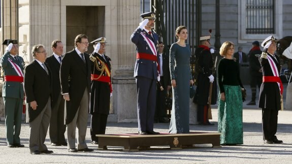 Los Reyes, el presidente Mariano Rajoy, el ministro del Interior, Juan Ignacio Zoido, y la ministra María Dolores de Cospedal escuchan ayer el himno en el patio del Palacio Real. :: efe