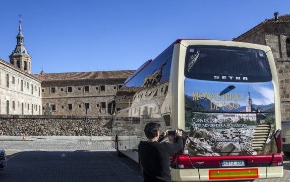 Un ciudadano fotografía la parte trasera del autobús serigrafiada con una imagen de San Millán. :: j. r.