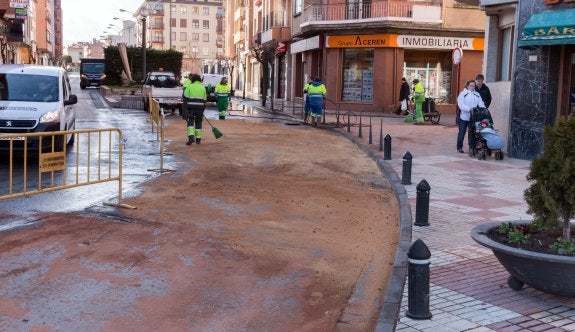 Operarios del servicio de limpieza, al mediodía de ayer, en labores de limpieza en la calle afectada por el escape. :: albo