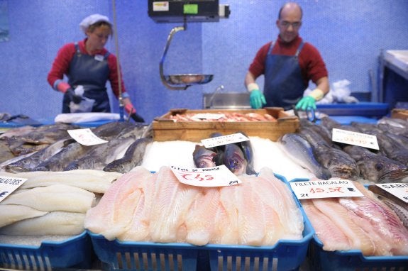 Filetes de panga fresco expuestos en una pescadería de un supermercado en San Sebastián, la semana pasada. A la izquierda, granjas de panga en la orilla  del río Mekong, en Vietnam. :: j.m.l. /reuters