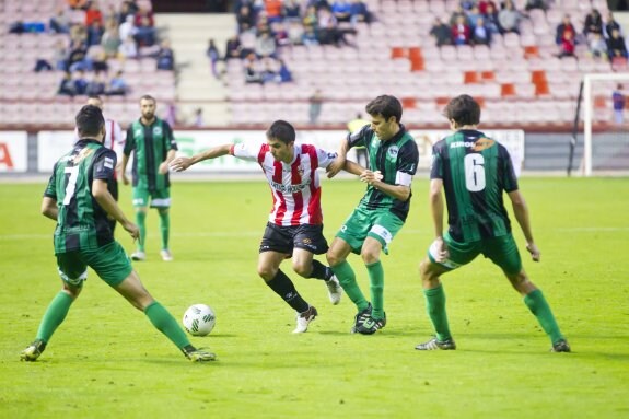 Tres verdinegros tapan la salida de Salvador, el autor del gol riojano, en el partido de Las Gaunas en la primera vuelta. :: JUSTO RODRÍGUEZ