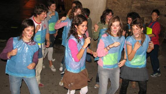 Un grupo de niños baila en un cuarto durante una celebración. 