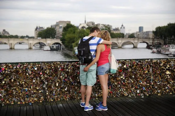 Una pareja se besa ante miles de candados en el Pont des Arts. :: efe 