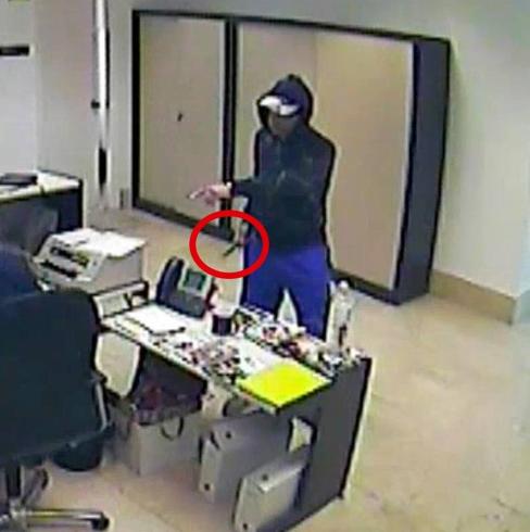 El ladrón, armado con un cuchillo, intimida al empleado de una sucursal bancaria. 