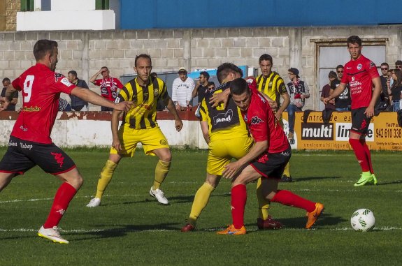 Un jugador del Laredo (de rojo) pelea por hacerse con el balón en un partido de la liga cántabra. :: d.m.
