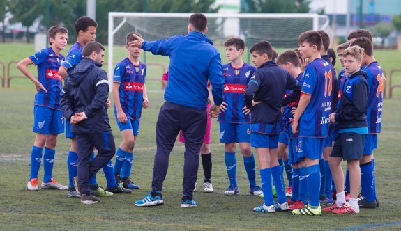 Instrucciones. El técnico del Comillas indica a sus jugadores la fórmula de juego antes de comenzar un partido en las instalaciones de Pradoviejo.