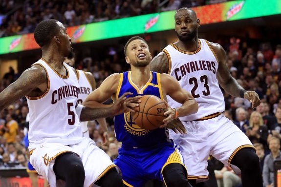 Curry, entra a canasta flanqueado por Smith (5) y LeBron (23). :: afp