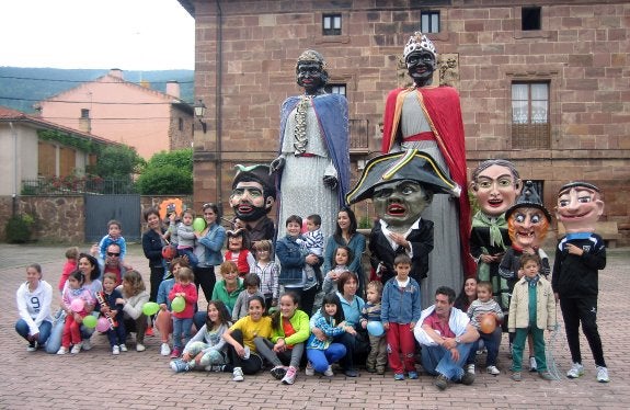 Los niños posan junto a gigantones y cabezudos. 