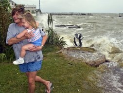 Una madre, con su hija en brazos, huye del ciclón en Gaveston./ AFP