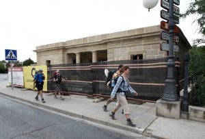 Un grupo de peregrinos pasa frente a uno de los fielatos, que se encuentran en obras./ DÍAZ URIEL