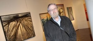 Julio Sabrás posa en su exposición en Caja Rioja junto al cuadro 'Vía muerta'. ::                             DÍAZ URIEL
