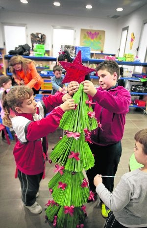 Los niños de Jun preparan en la ludoteca los adornos que colocarán en las calles, en las farolas y en edificios municipales. El pueblo se ahorrará más de 20.000 euros. ::
RAMÓN L. PÉREZ