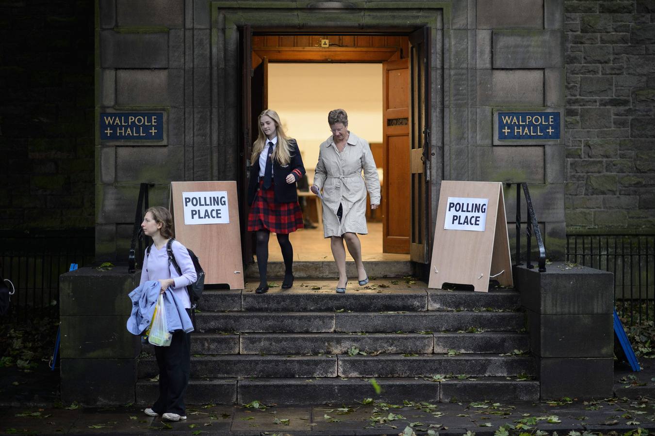 Escocia ya decide su futuro. Algunos escoceses salen y entran de un colegio electoral de Edimburgo.