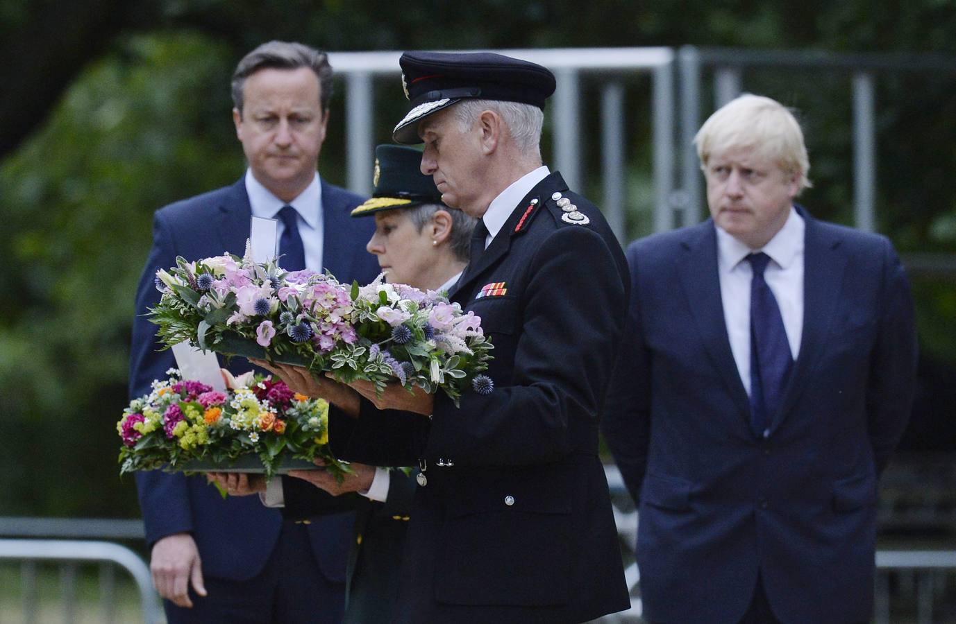 El primer ministro británico, David Cameron (i), y el alcalde de Londres, Boris Johnson (d), participan en la ceremonia conmemorativa ante el monumento a las víctimas del 7-J en Hyde Park, Londres.