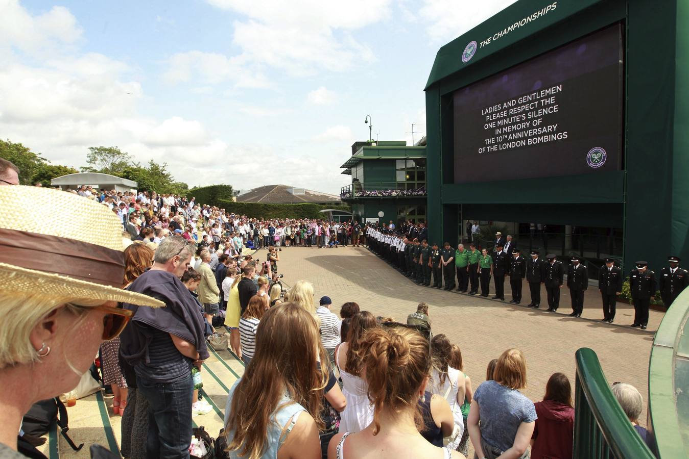 Miembros del público y empleados de la organización del torneo de Wimbledon guardan un miunto de silencio en homenaje a las víctimas de los atentados terroristas.